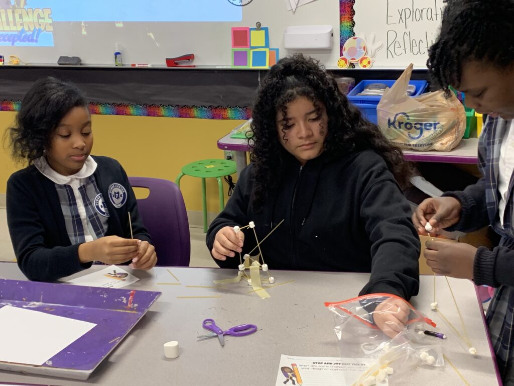 Youth building spaghetti tower.